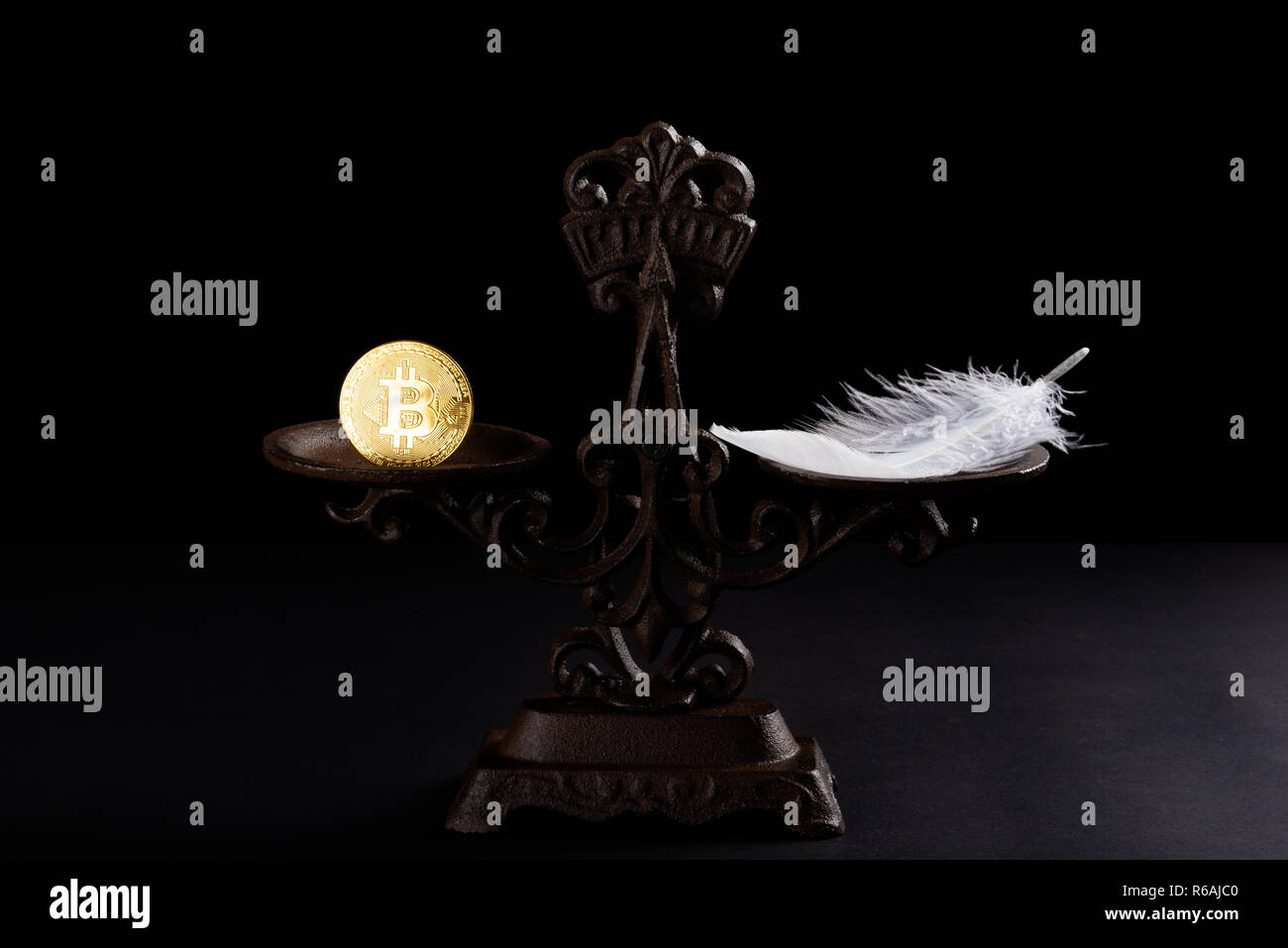 bitcoin and feather on a balanced scale concept of the value of bitcoins worthless Stock Photo