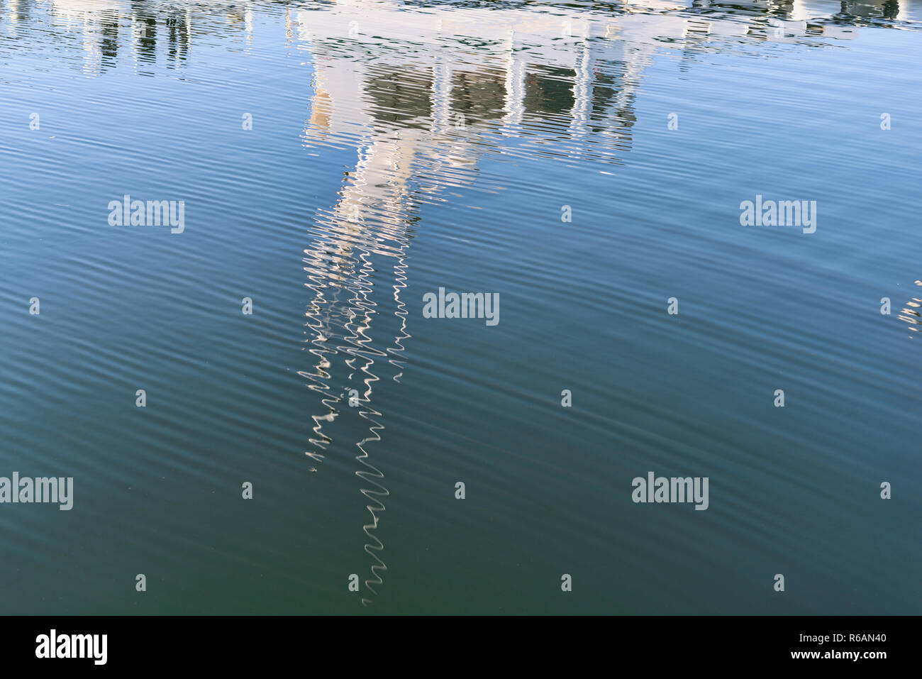 Blurred reflection of a cruising motorboat on the rippling surface of ...