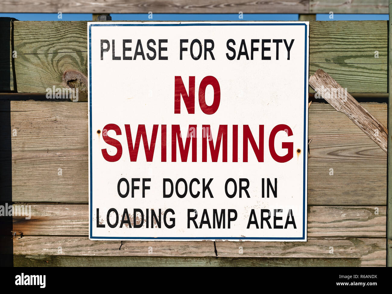 Close view of a no swimming sign on a public pier. Stock Photo