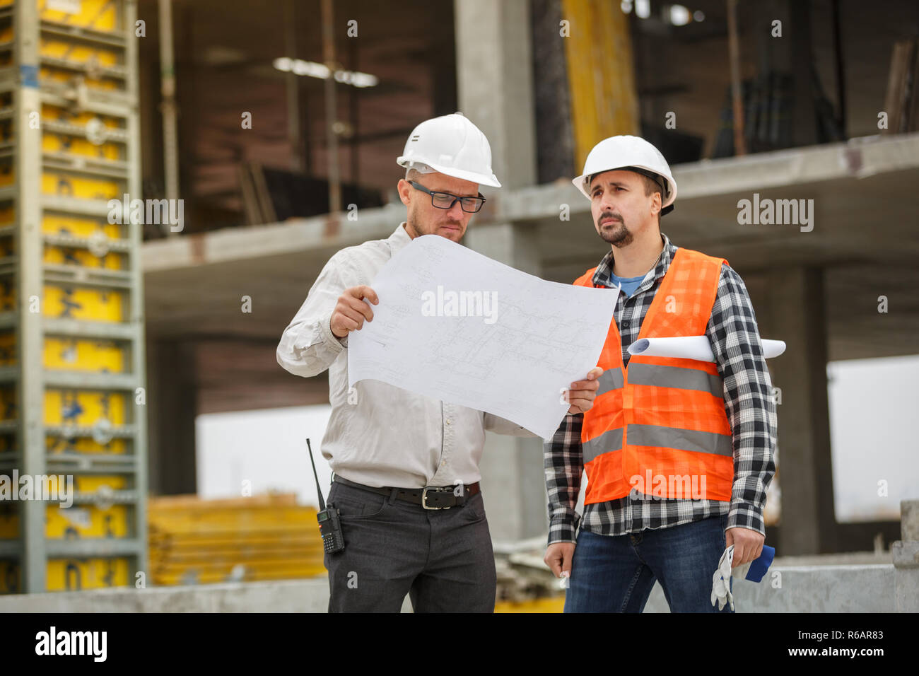 Male architect and developer discussing blueprints of an architect