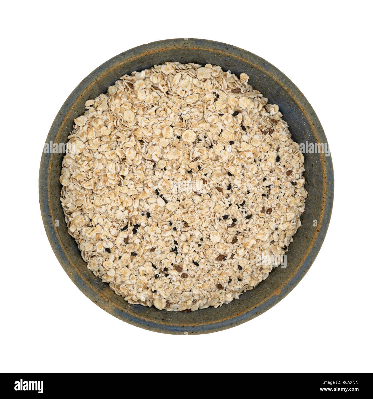 Top view of a bowl of dry oatmeal mixed with flaxseed and chia seeds