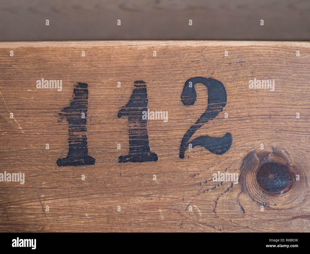 Number 112 on wooden surface Stock Photo