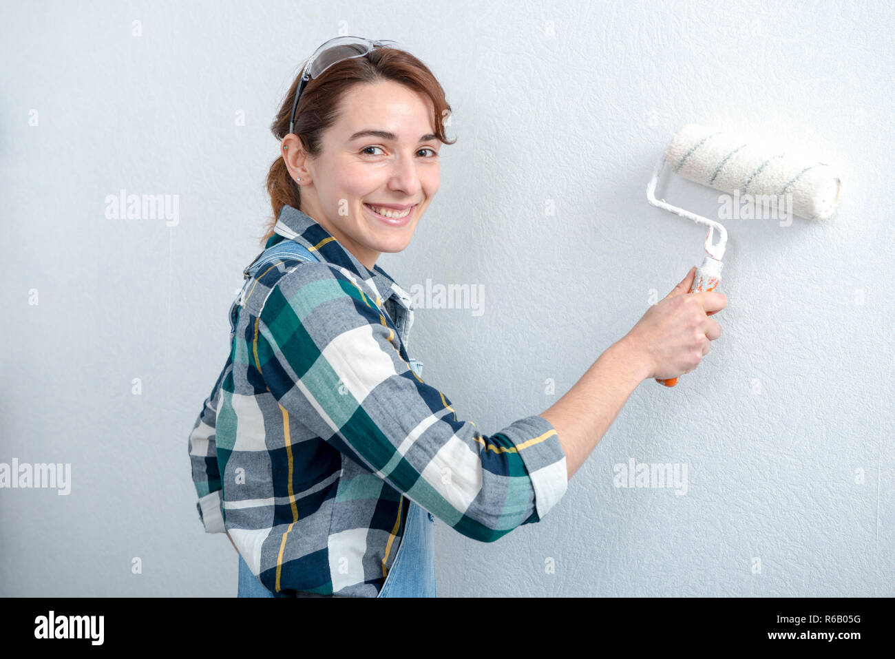 pretty young woman painting the wall Stock Photo - Alamy