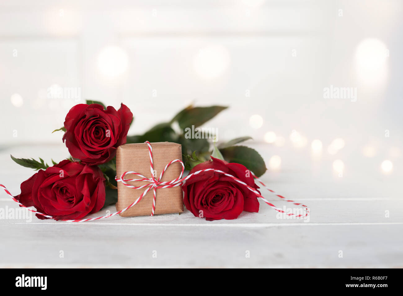 romantic red roses with a gift on white background Stock Photo - Alamy