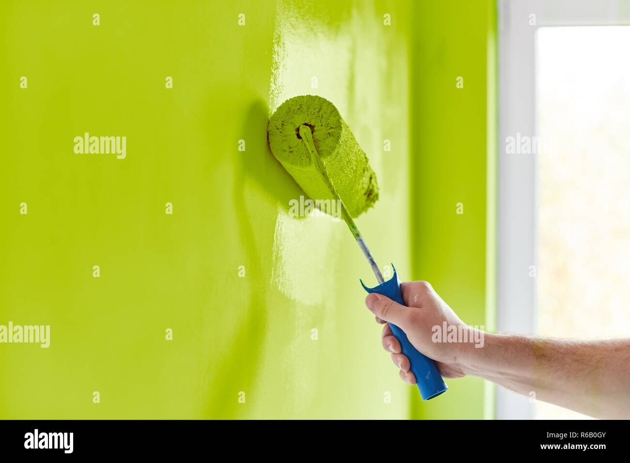 Male hand painting wall with paint roller. Painting apartment ...