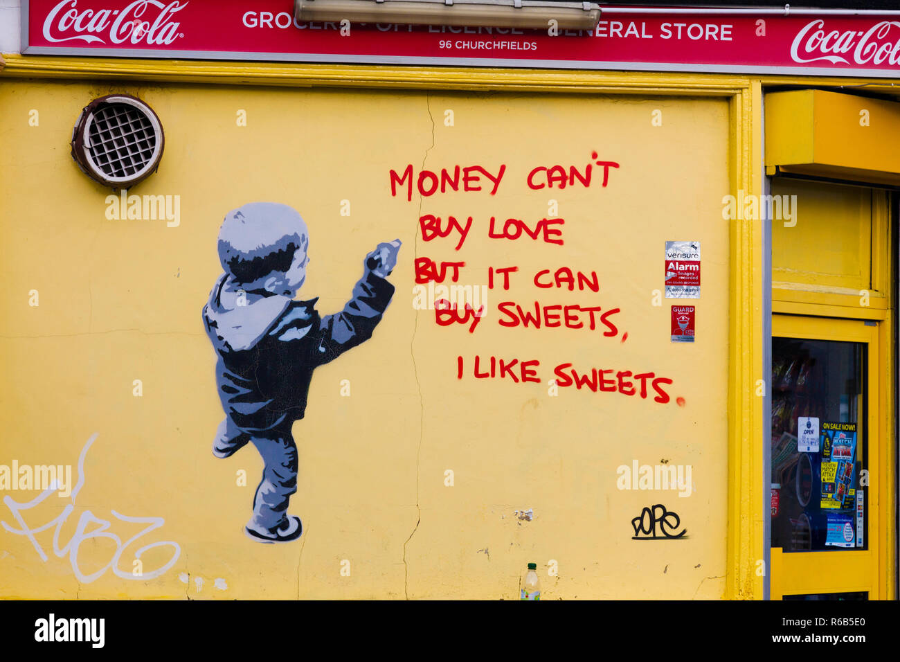 'I like sweets', Banksy style graffiti on a wall of a south London corner grocery shop. Stock Photo