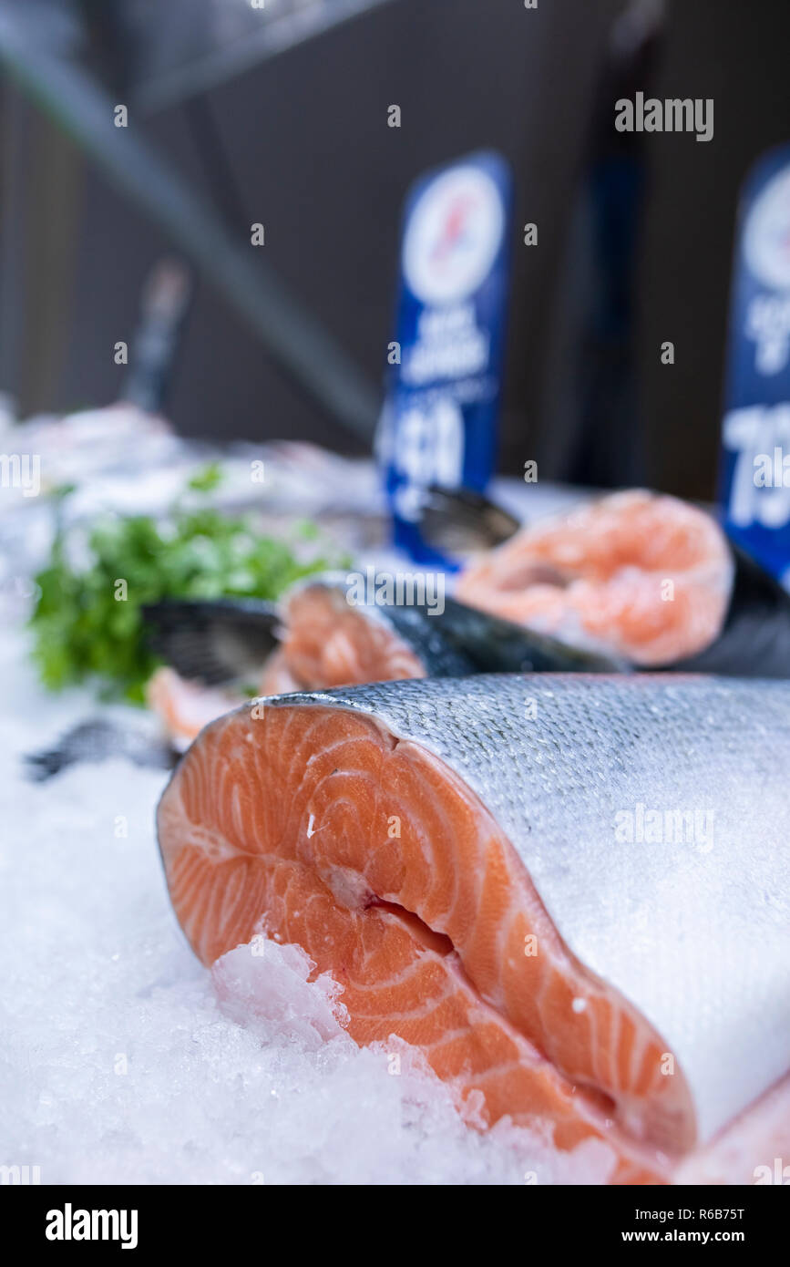 Fresh salmon fish on ice on seafood display at supermarket Stock Photo