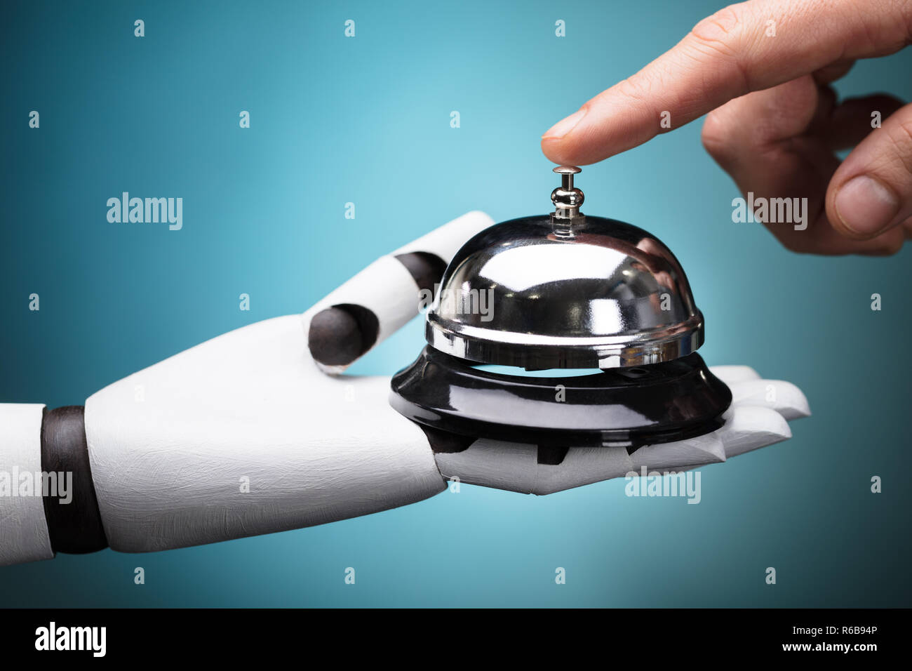 Person Ringing Service Bell Hold By Robot Stock Photo