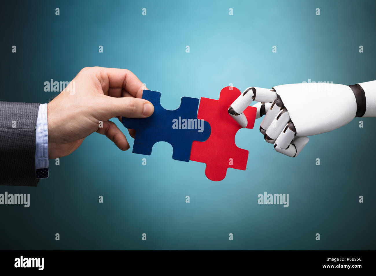 Businessperson And Robot Holding Jigsaw Puzzle Stock Photo