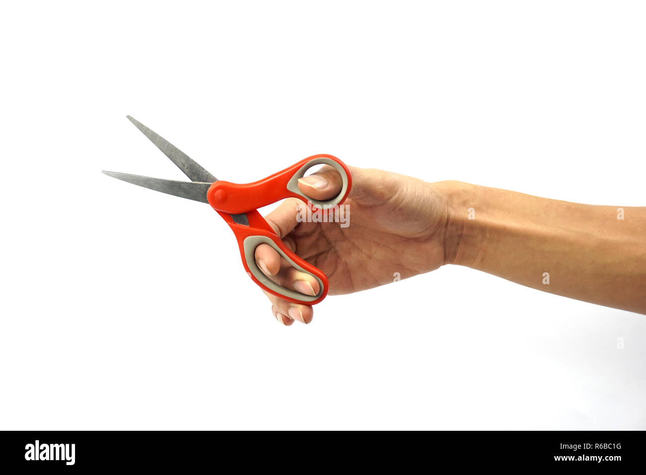 A Cropped of man hand holding red metal scissors against white background. Stock Photo