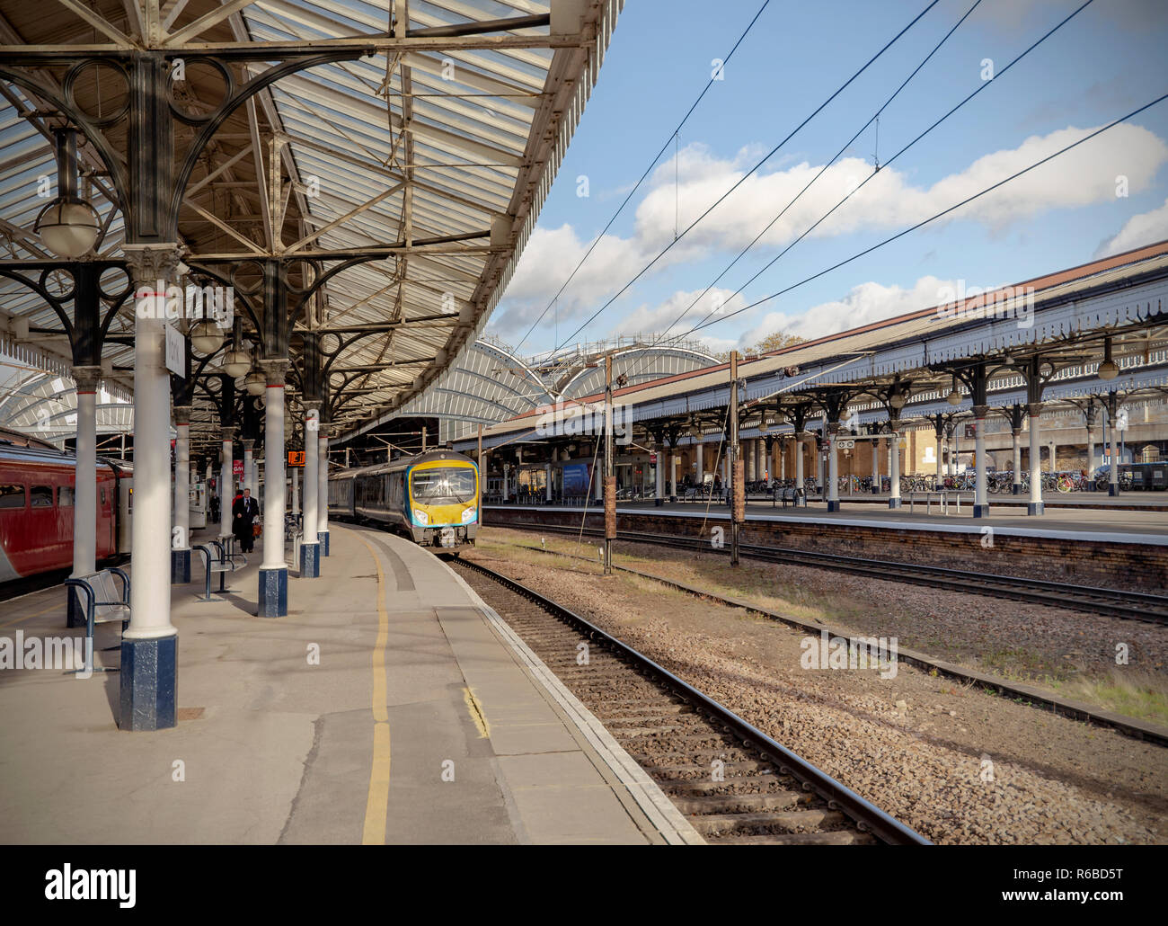 A platform at York Railway Station on a sunny afternoon. Shadows fall onto the platform while