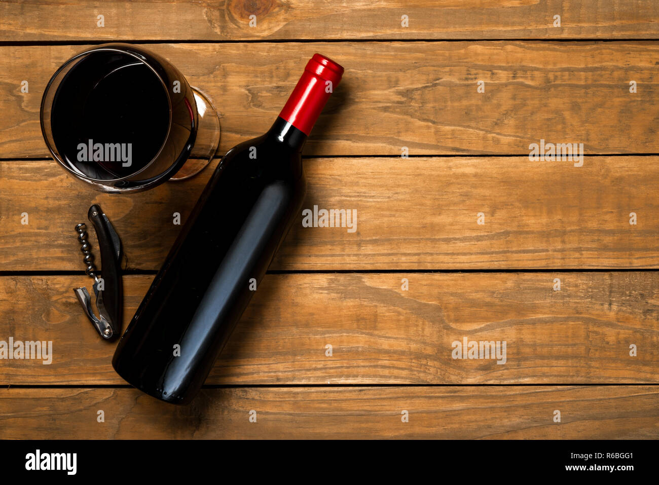 Bottle of wine glass and corkscrew on wooden background. Top view with copy space. Stock Photo