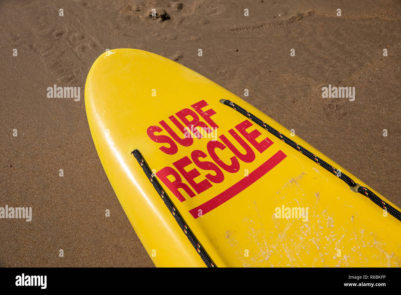 Lifeguard yellow board on the wet sand Stock Photo