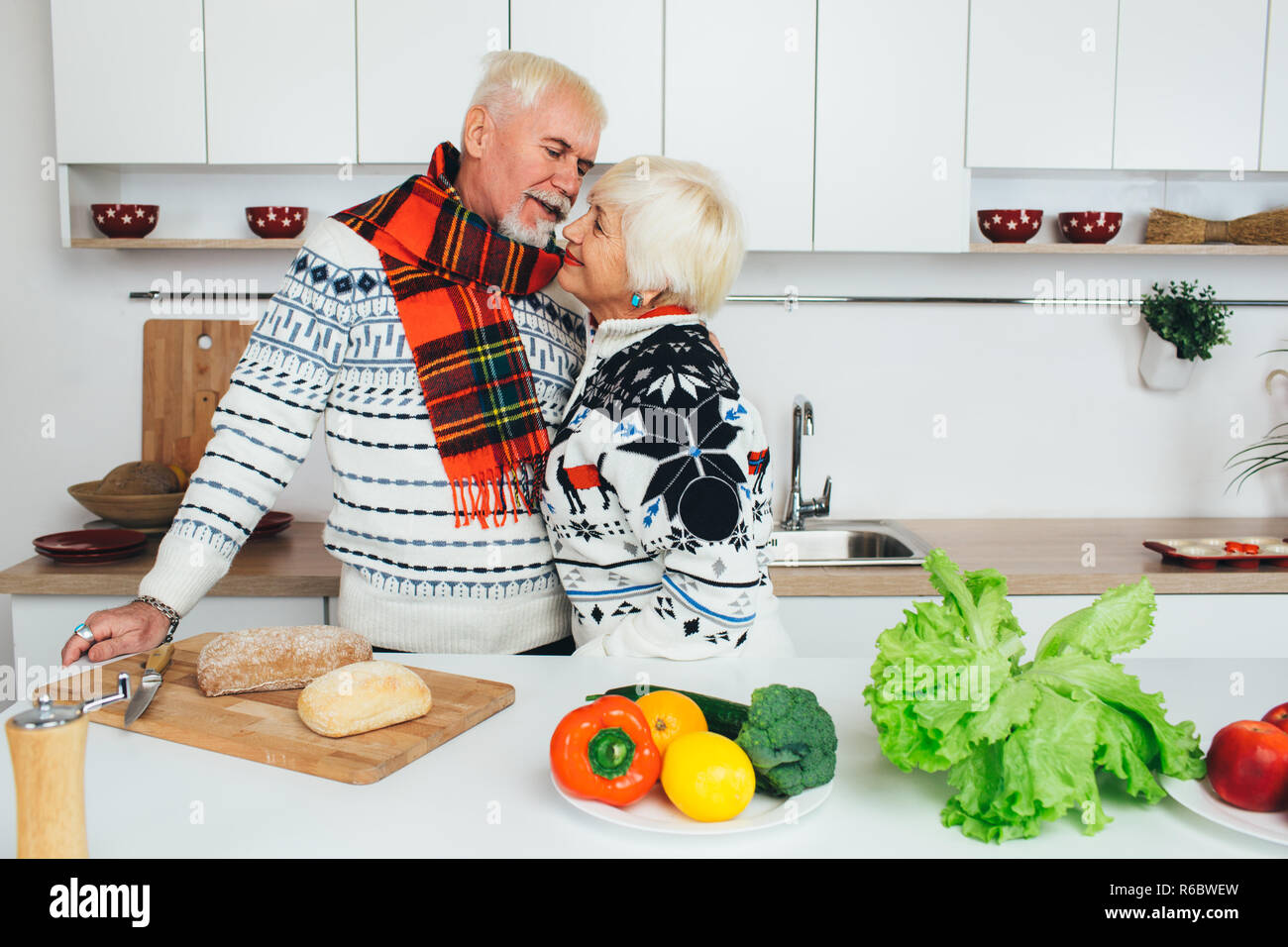 Senior couple cooking healthy eat and smiling at each other at kitchen Stock Photo