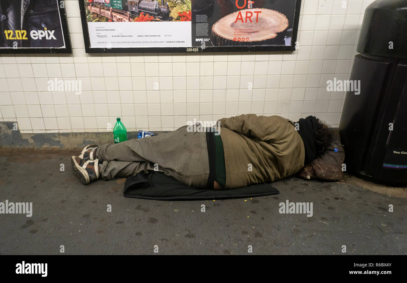 A homeless individual is seen sleeping in a Chelsea subway station in New York on Friday, November 30, 2018. (Â© Richard B. Levine) Stock Photo