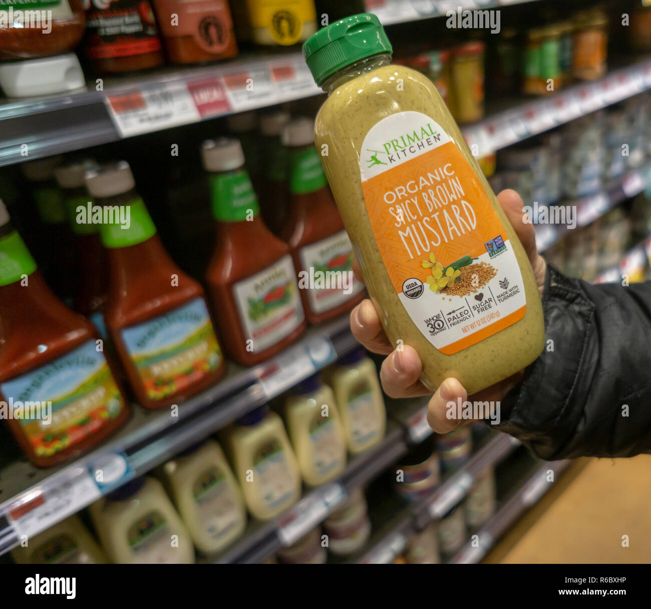 A shopper chooses a bottle of Primal Kitchen brand Organic Spicy Brown mustard in a supermarket in New York on Thursday, November 29, 2018. Kraft Heinz announced it will buy the paleo diet condiment and dressing company Primal Kitchen for $200 million. (Â© Richard B. Levine) Stock Photo