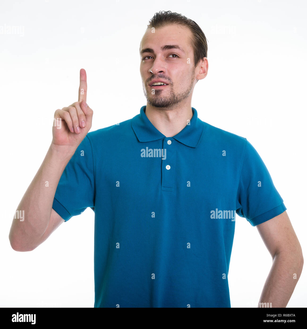 Studio shot of young bearded man pointing finger up while thinki Stock Photo