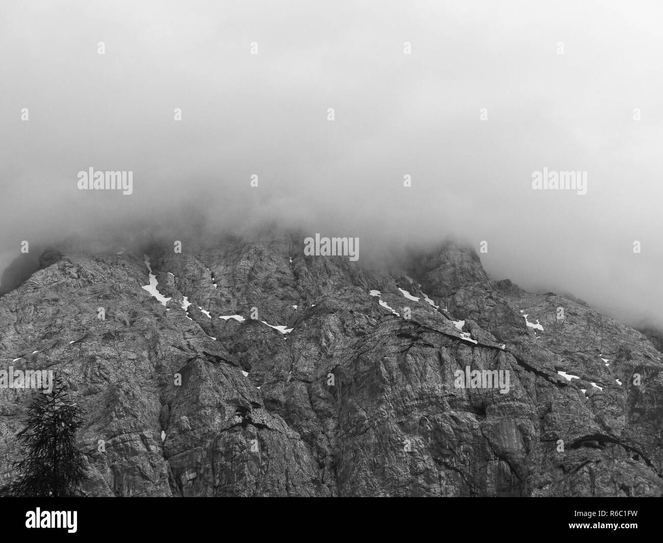 The Alps Near Ehrwald In Tyrol, Rock Face Partly In Clouds, Clouds Lying On The Mount Peak, Austria Stock Photo