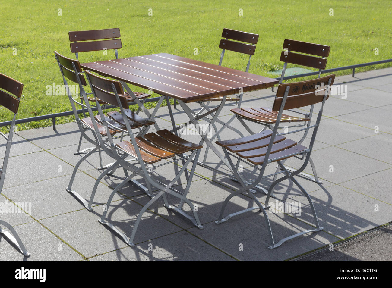 Table And Six Chairs On The Sidewalk Stock Photo