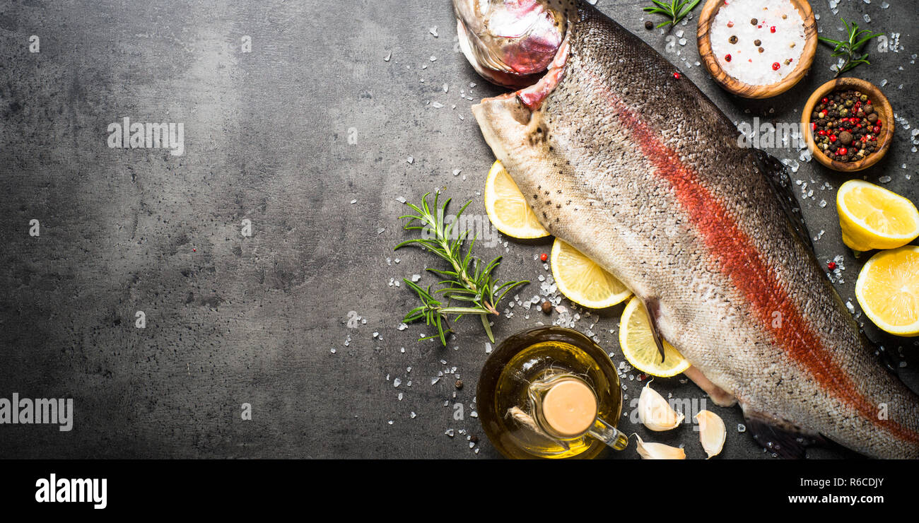 Raw salmon fish whole with ingredients for cookings on black Stock ...