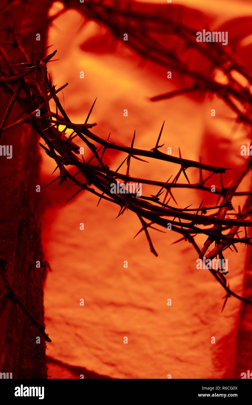 closeup of blood red crown of thorns on linen and a wooden beam from the cross Stock Photo
