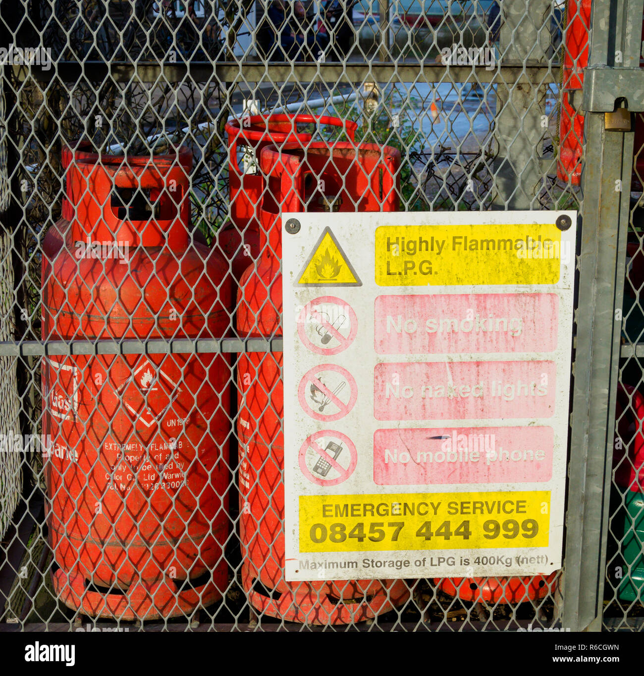 Gas Bottles in locked cage with warning signs Stock Photo