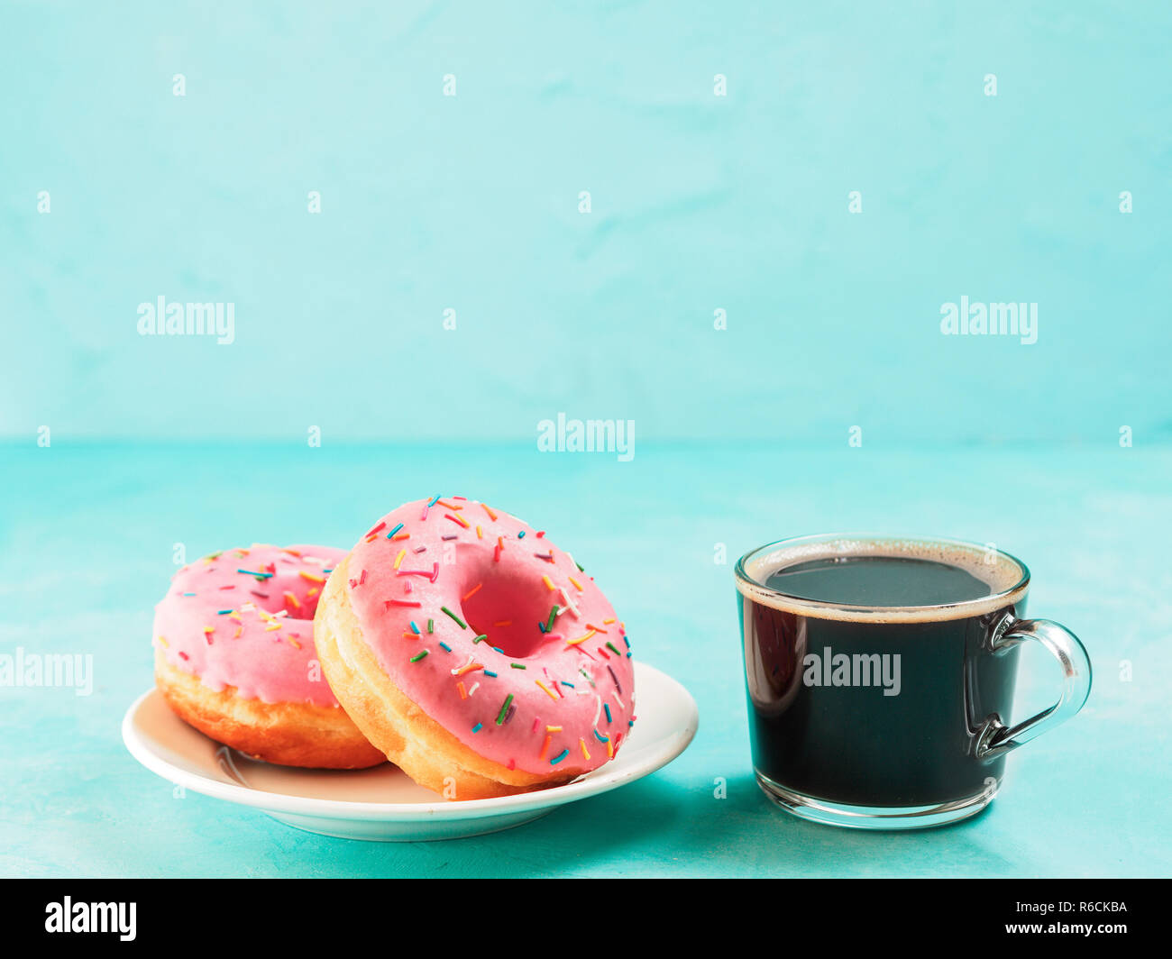 pink donuts on blue background , copy space Stock Photo - Alamy