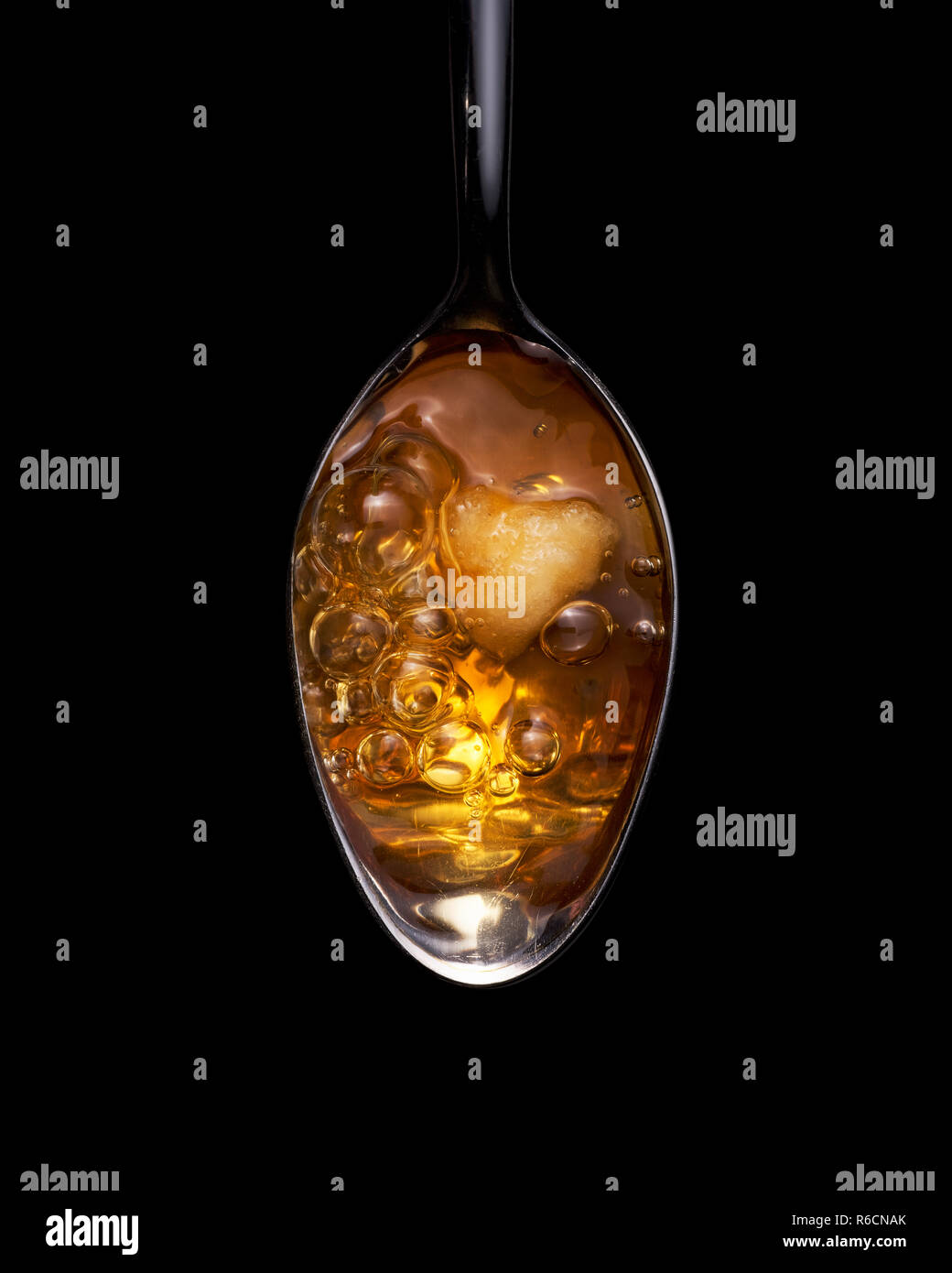 View from above of amber coloured heroin bubbling on a spoon Stock Photo