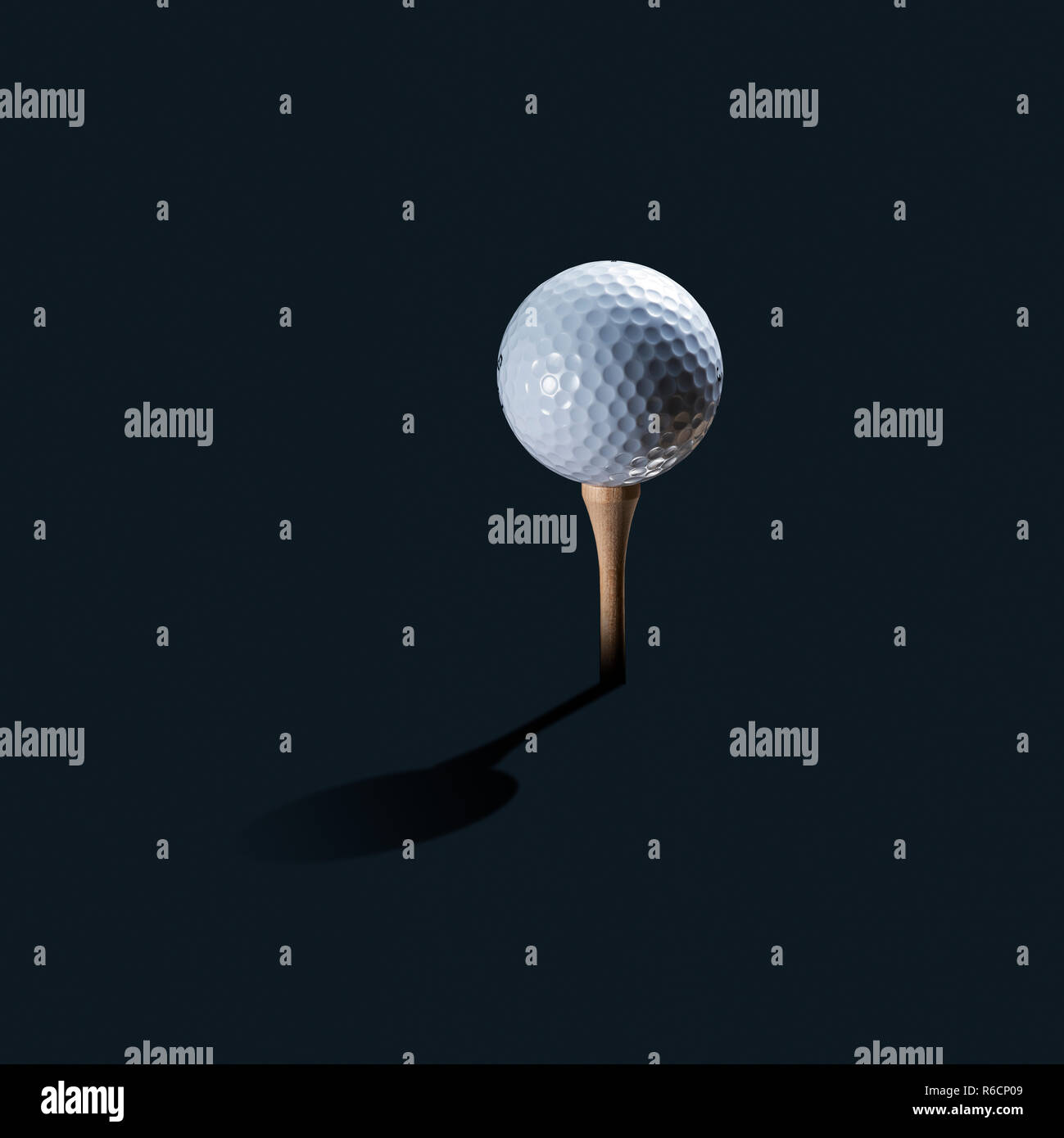 White golf ball on wooden tee as still life with shadow and dark background Stock Photo