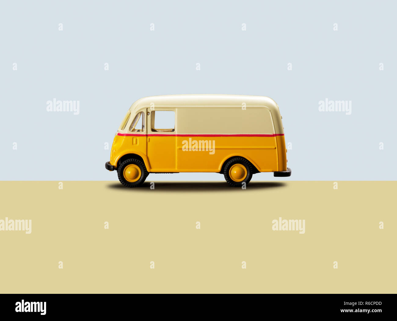 Retro yellow toy metal camper van against a plain background Stock Photo