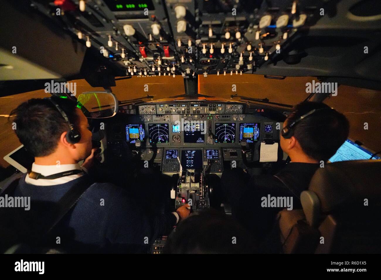 (181205) -- BEIJING, Dec. 5, 2018 (Xinhua) -- Gao Yujie (L) and Yuan Biao, captains of the Shandong Airlines, prepare for a verification takeoff of a Boeing B738 at Capital International Airport in Beijing, capital of China, Dec. 4, 2018. The Civil Aviation Administration of China (CAAC) on Tuesday made the first verification takeoff based on the Head Up Display (HUD) under Runway Visual Range (RVR) of 90-meter low visibility. The success of the takeoff symbolized that 80 percent of difficulties relating to the low-visibility takeoff will be solved, which can further guarantee the regularity o Stock Photo