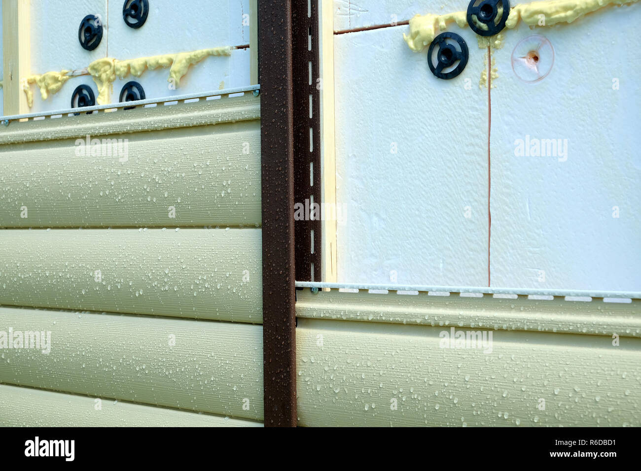 Siding panels mounting over insulation on building wall front view