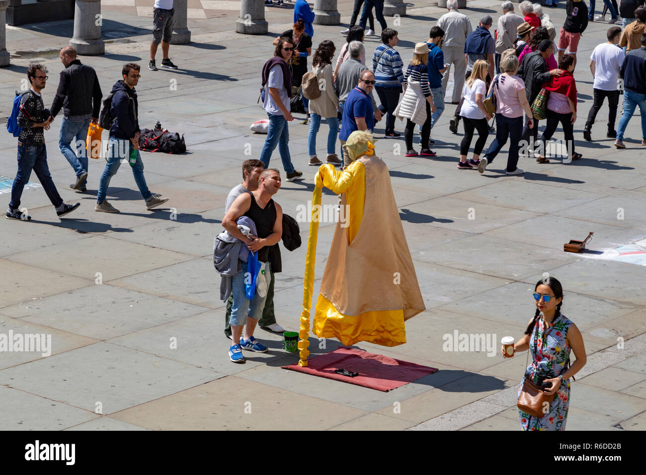 Street performer dressed as Yoda. The performer is creating the