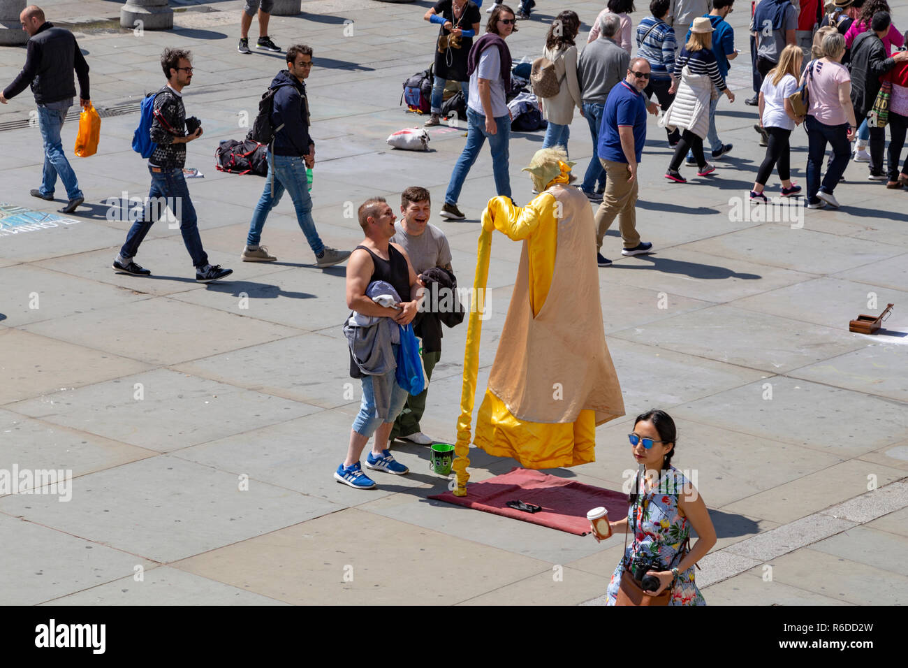 Street performer dressed as Yoda. The performer is creating the