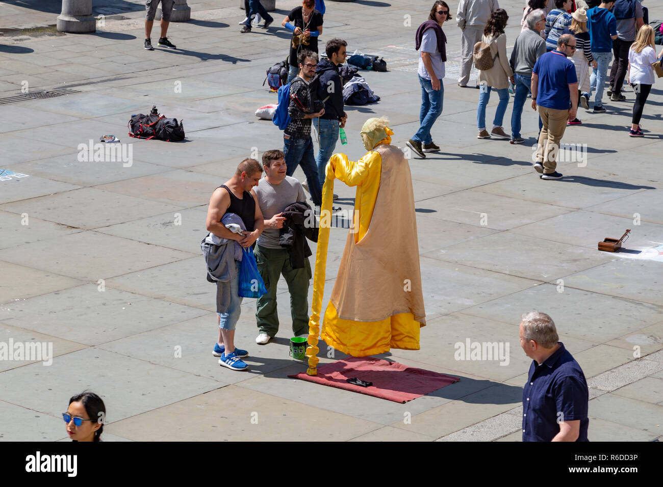 Street performer dressed as Yoda. The performer is creating the