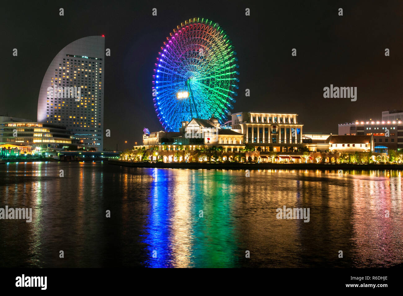 Illuminated Night Scene Of The Shinko Area In The Minato Mirai 21 District Of Yokohama, Japan Including The Cosmo World Amusement Park Stock Photo