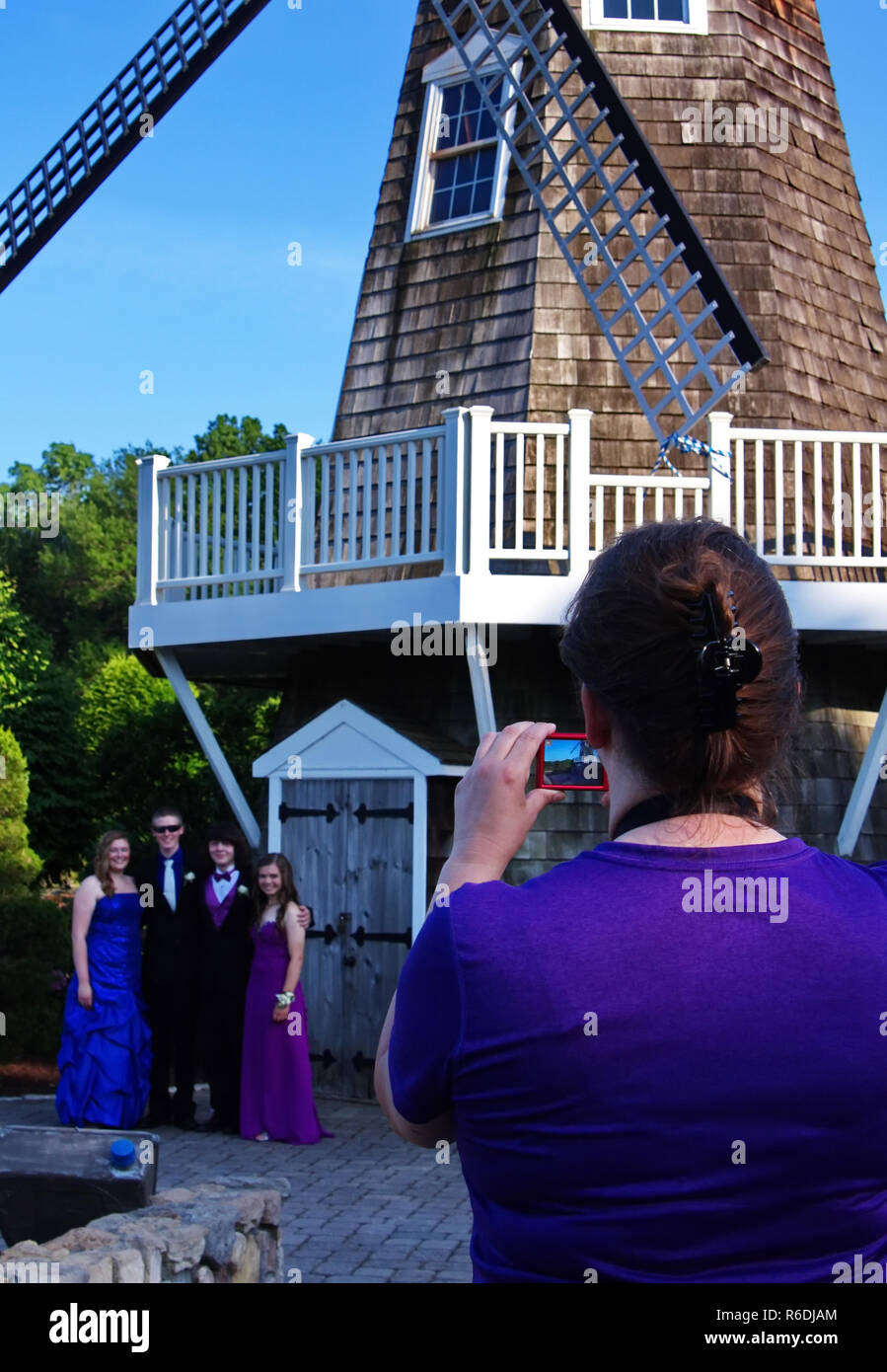 Plainville, CT USA. June 2013. Mom with smartphone happily records this special event of her kids prom night. Stock Photo