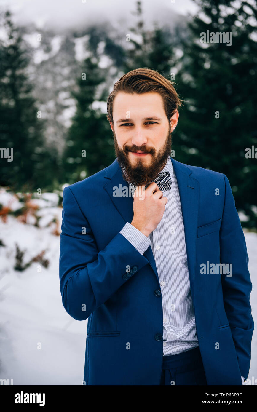 groom in a blue suit in the mountains Carpathians Stock Photo