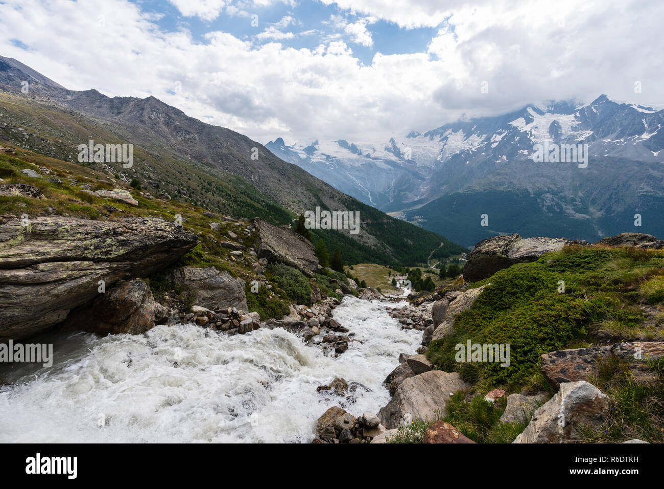 A river cascades down the mountainside above Saas Grund, Valais, Switzerland. Stock Photo