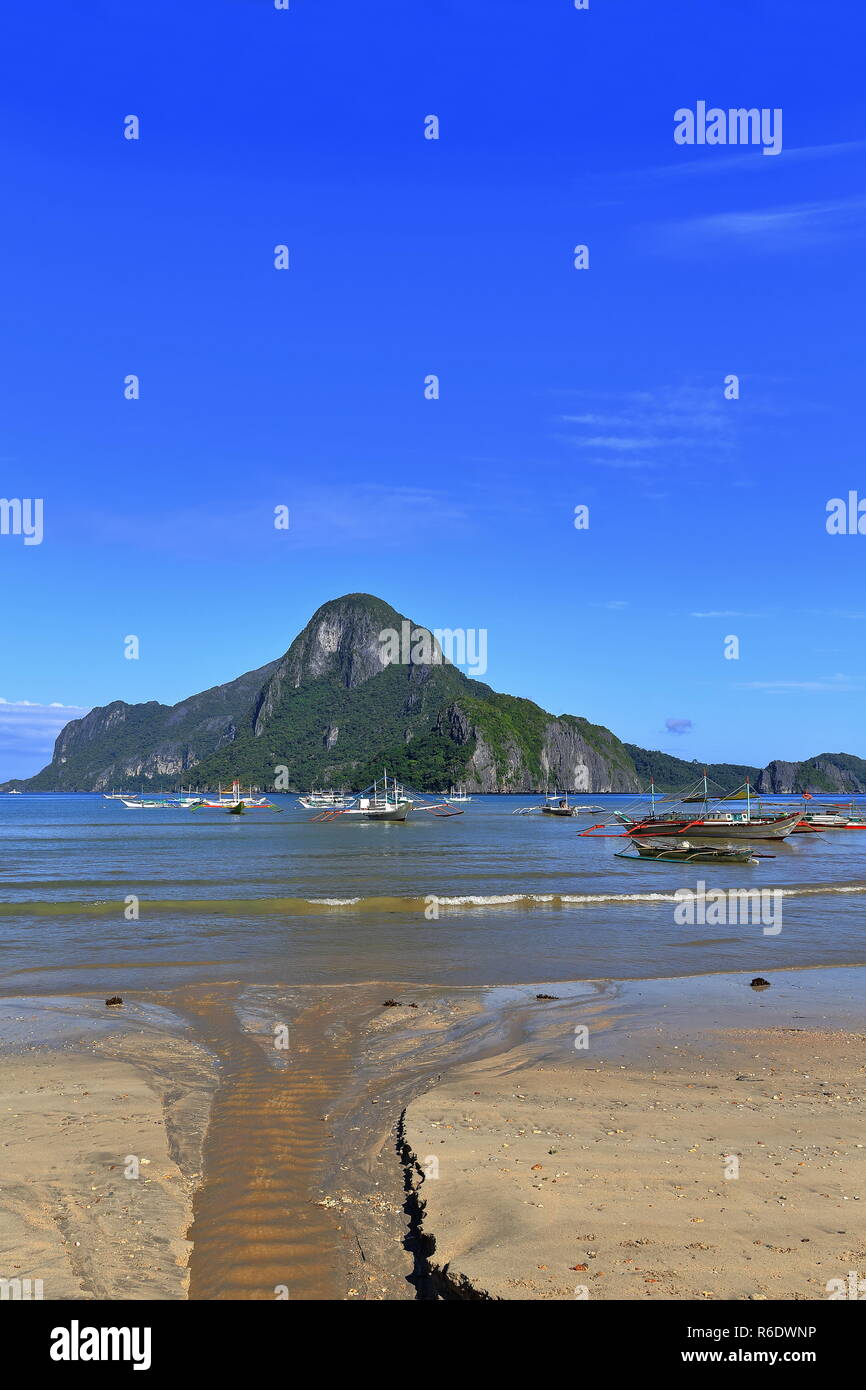 Tour and fishing boats moored at the beach-Bacuit bay in a sunny morning ready for going out to sea on their usual fishing-island hopping tasks. Brook Stock Photo