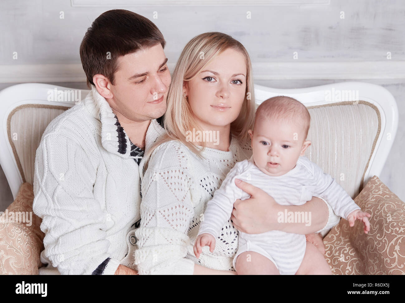 happy family sitting on the couch in the cozy living room Stock Photo ...