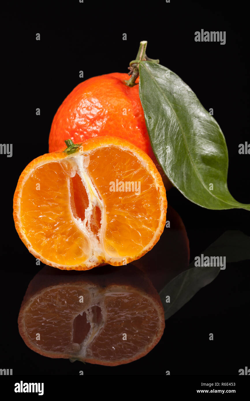 Fruits of mandarin orange ,whole and cut, on black background Stock ...