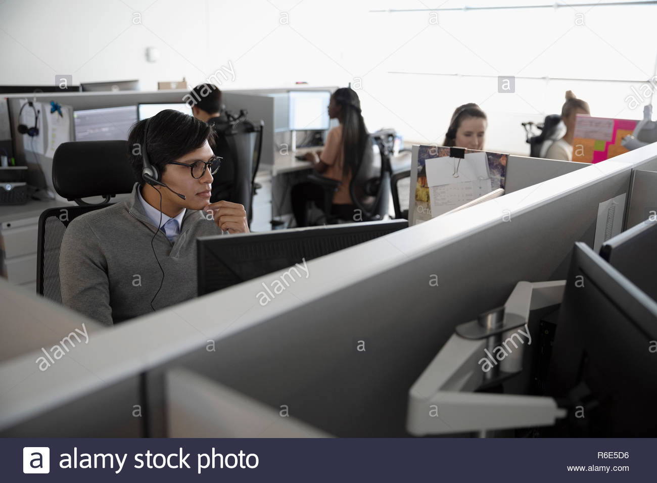 Man with headset working in cubicle at call center Stock Photo