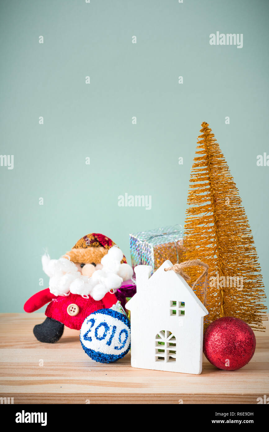 Christmas background. A small gold Christmas tree and boxes with gifts on a wooden table. Green background. Space for text. New Year's background. Stock Photo