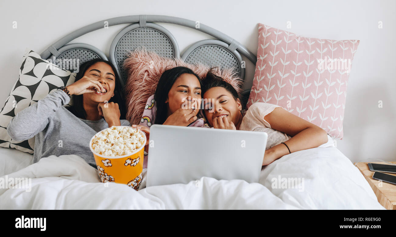 https://c8.alamy.com/comp/R6E9G0/girls-having-a-sleepover-enjoying-a-movie-on-laptop-with-popcorns-three-young-girls-having-fun-watching-movie-on-laptop-eating-popcorns-in-a-tub-duri-R6E9G0.jpg