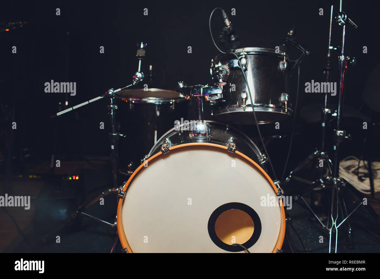 Modern drum set shot in smoky dark studio. Stock Photo
