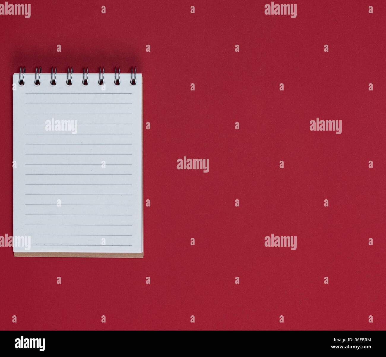 small notebook with empty white sheets in line, red background, empty space Stock Photo