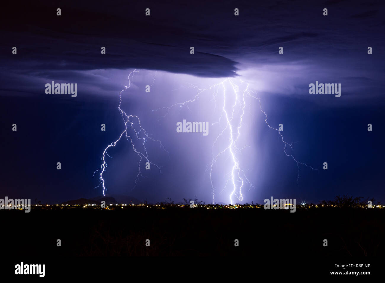 Lightning bolts strike the mountains near Casa Grande Arizona during a monsoon storm Stock Photo