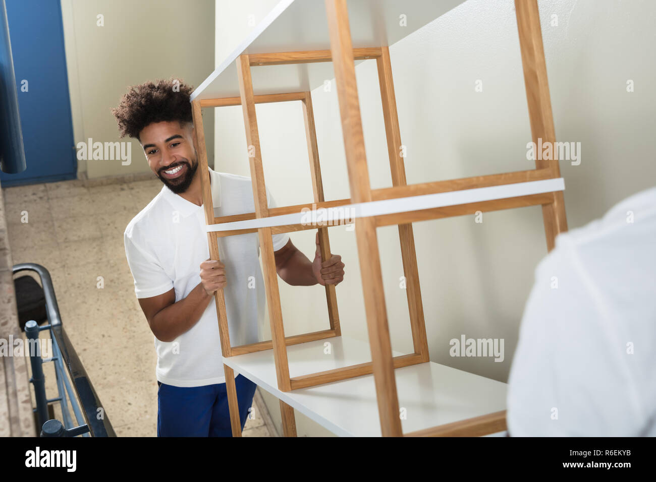Two Male Movers Carrying The Empty Shelf At Home Stock Photo Alamy