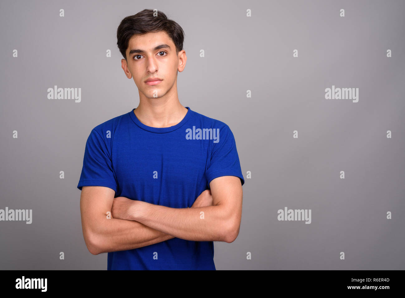 Young handsome Persian teenage boy with arms crossed Stock Photo